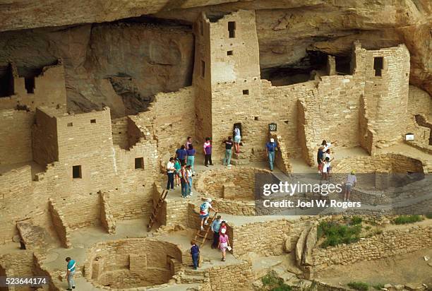 tourists at the anasazi cliff dwellings - cliff dwelling stock-fotos und bilder