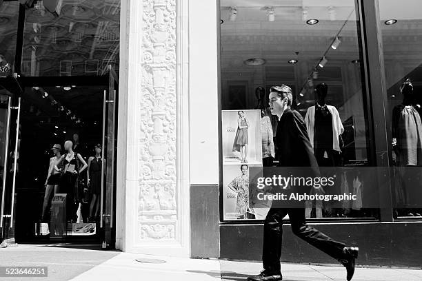 shopper a piedi lungo un marciapiede - reportage foto e immagini stock