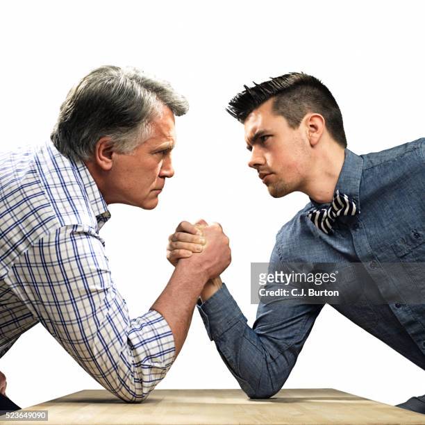 middle-aged man arm wrestling young man - arm wrestle stock pictures, royalty-free photos & images
