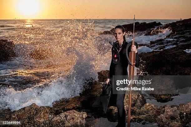 young woman with speargun on rocky beach, palos verdes peninsula, los angeles county, california, usa - woman spear fishing stock pictures, royalty-free photos & images