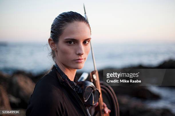 portrait of young woman with speargun, palos verdes peninsula, los angeles county, california, usa - woman spear fishing stockfoto's en -beelden