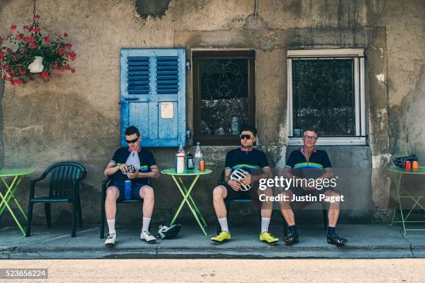 three cyclists at alpine cafe - elastane foto e immagini stock