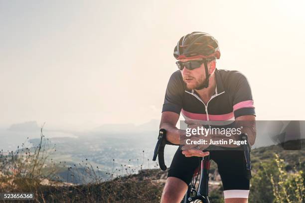 cyclist resting on cumbre del sol, benitachell, spain - spandex stockfoto's en -beelden