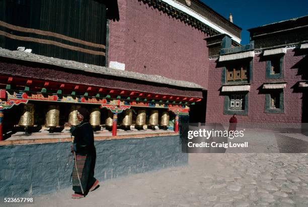pilgrim at prayer wheels - prayer wheel stock pictures, royalty-free photos & images