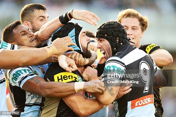 Michael Ennis of the Sharks wrestles with Jamie Soward of the Panthers after a hit on Matt Moylan of the Panthers by Luke Lewis of the Sharks during...