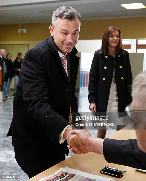 The candidat of the far-right Freedom Party Norbert Hofer shakes hands as he arrives at the polling station at the first round of Austrian President...