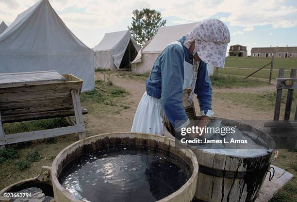 woman in historic costume washing clothes in a barrel - fort laramie stock pictures, royalty-free photos & images