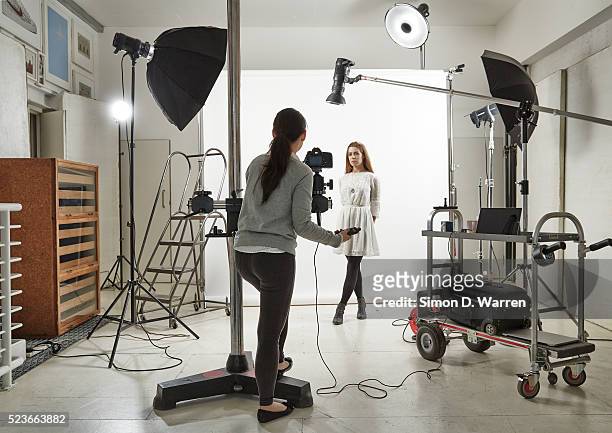 woman posing in photographic studio - photographer stock-fotos und bilder
