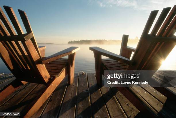 adirondack chairs on a wooden dock - chaise adirondack photos et images de collection