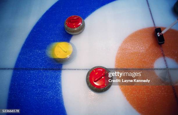 curling stones moving over the ice - curling fotografías e imágenes de stock