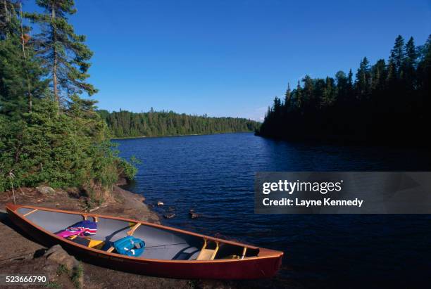 canoe along lakeshore - boundary waters canoe area stock pictures, royalty-free photos & images