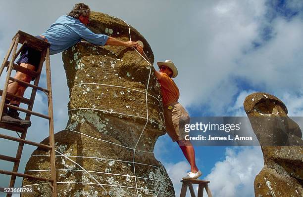 archaeologists putting grid on moai - archaeologist stock pictures, royalty-free photos & images