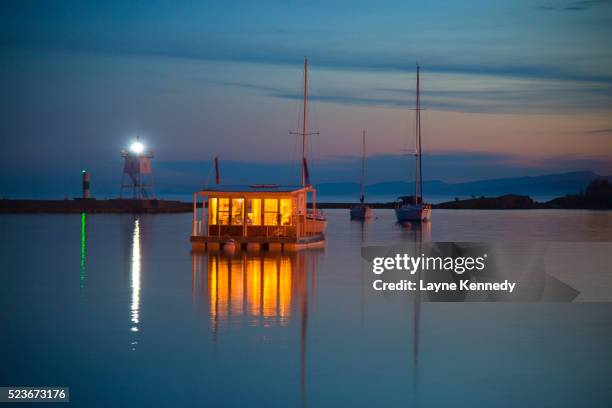 houseboat on lake superior lite up in grand marais harbor, minnesota - hausboot stock-fotos und bilder