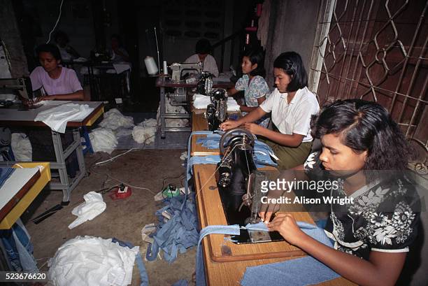 burmese refugees sewing in sweatshop - sweatshop stock-fotos und bilder
