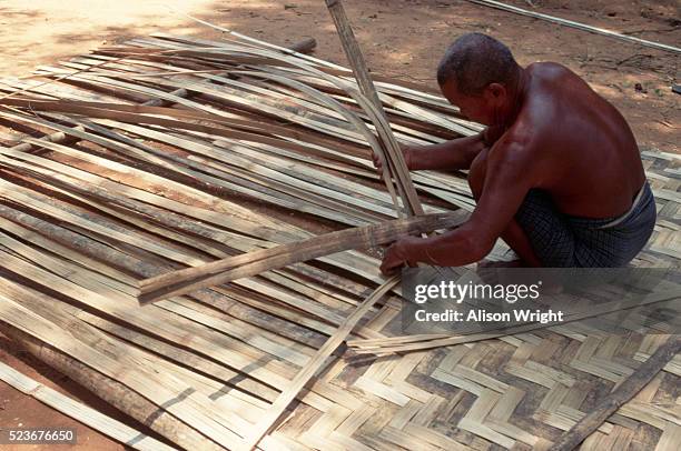 man weaving mat of palm fronds - fronda fotografías e imágenes de stock