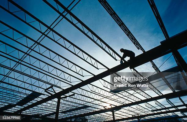 construction worker standing on beams - balkengerüst stock-fotos und bilder