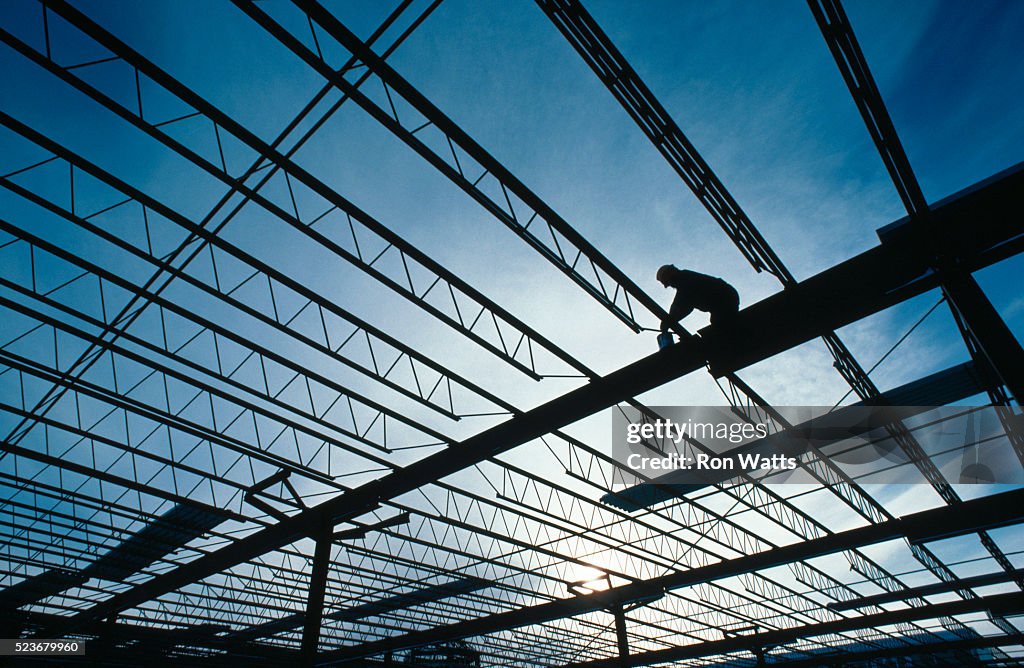 Construction Worker Standing on Beams