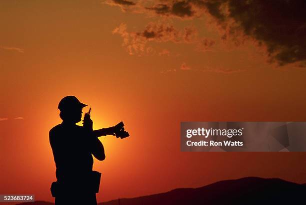 silhouetted lifeguard talking on walkie-talkie - walkie talkie stock pictures, royalty-free photos & images