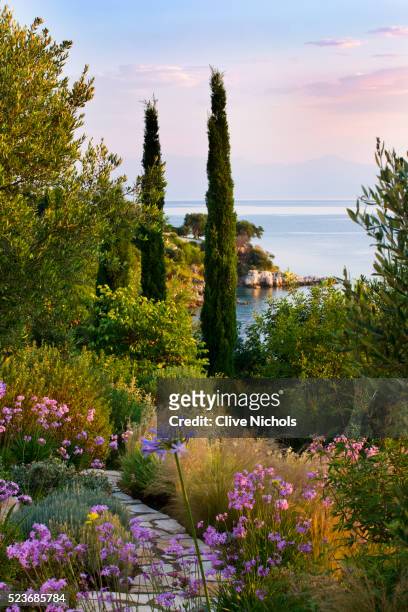 corfu, greece - the kassiopia estate: view out to sea from garden with stone path, stipa tenuissuim - stipa stock pictures, royalty-free photos & images