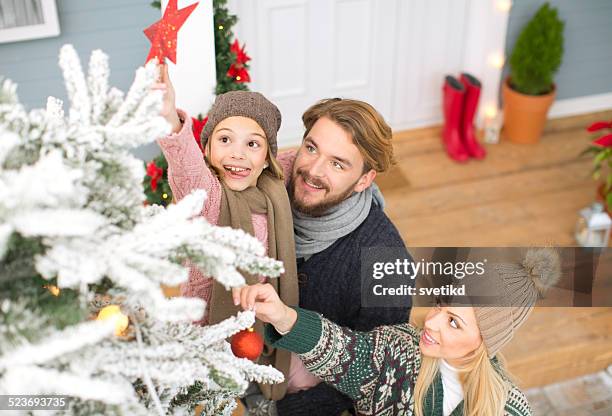 family decorating christmas tree. - family tree stockfoto's en -beelden