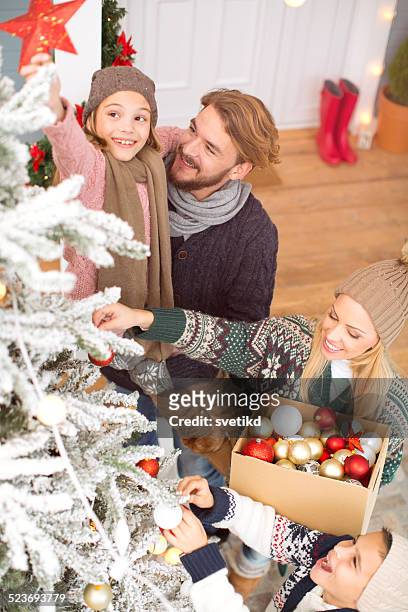 family decorating christmas tree. - decorated christmas trees outside stockfoto's en -beelden