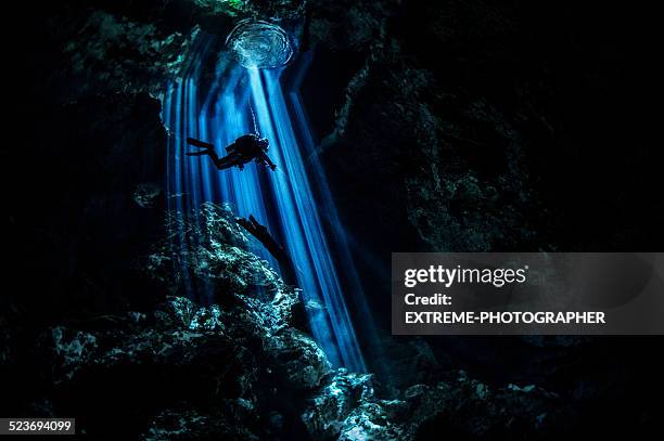 rays of light in dark underwater cave - potholing stock pictures, royalty-free photos & images
