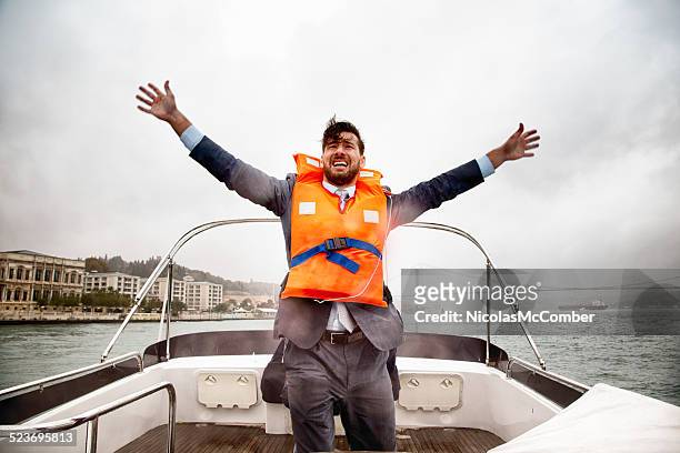 anxious businessman waves for help on sinking ship - sunken stock pictures, royalty-free photos & images