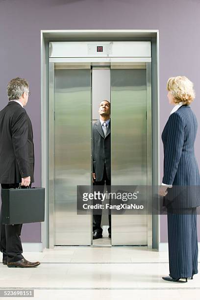 administrative workers waiting for elevator - elevator door stock pictures, royalty-free photos & images