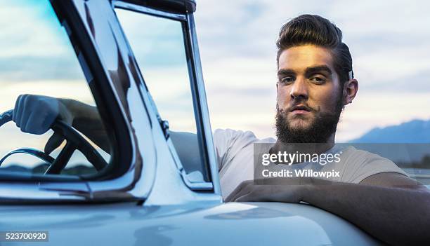 años cincuenta sudaca pompadour hipster chico conducción convertible coche clásico - pompadour fotografías e imágenes de stock