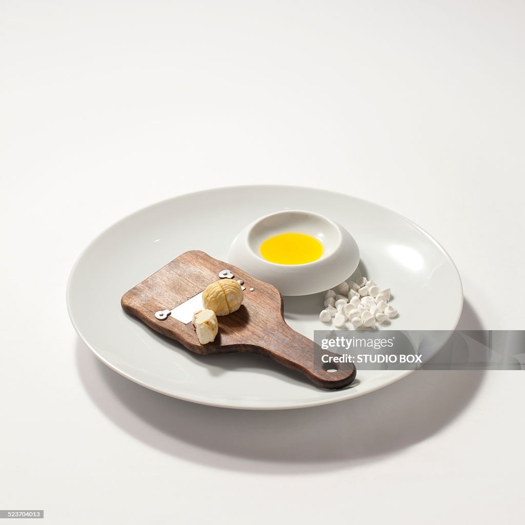 Dish with oil, chestnuts and sugar foam