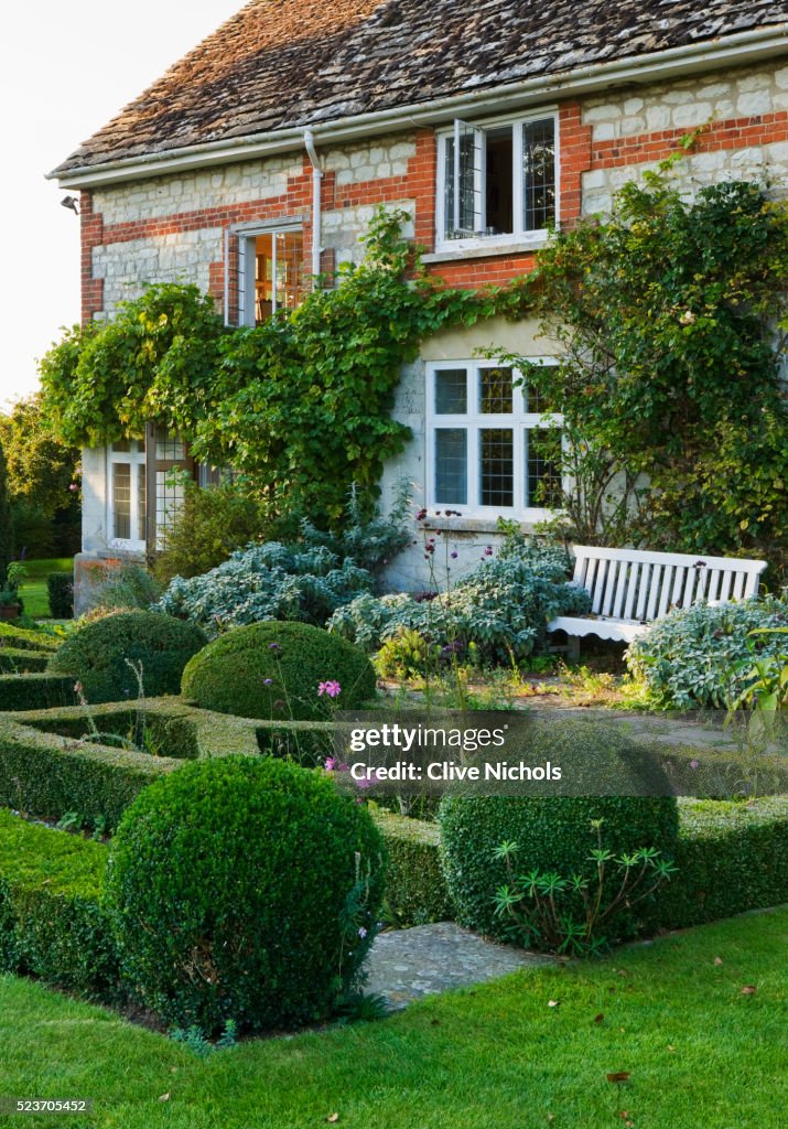 Woolstone Mill house, Oxfordshire: The house with Formal Parterre, Box Balls and Bench.