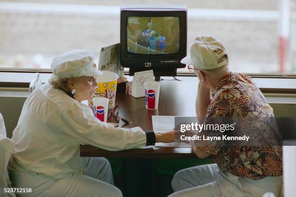 elderly couple watching horse races at the track - 90s tv set stock pictures, royalty-free photos & images