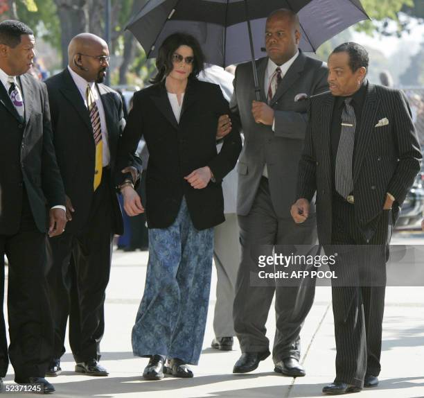 Michael Jackson is aided by bodyguards as he arrives more than an hour late with his father Joe Jackson for his child molestation trial at the Santa...