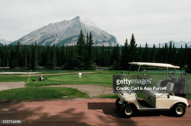 golfers and cart at banff springs golf course - banff springs golf course stock pictures, royalty-free photos & images