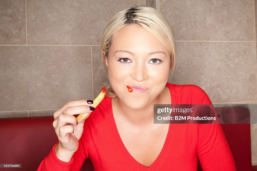 Woman at eafe eating french fries