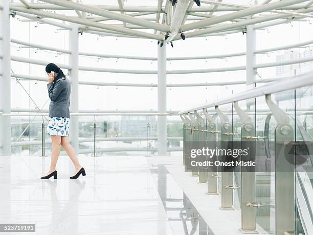 asian businesswoman talking on celphone - celphone stock-fotos und bilder