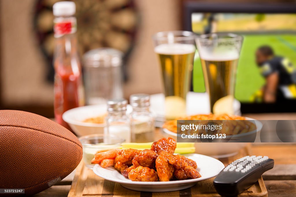 Watching football game on television at local pub. Food, beer.