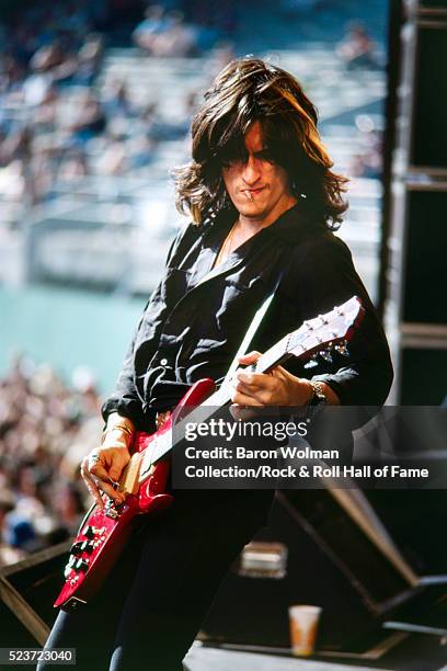 Joe Perry, the American lead guitarist, backing vocalist and contributing songwriter for the American rock band Aerosmith, plays guitar on stage.