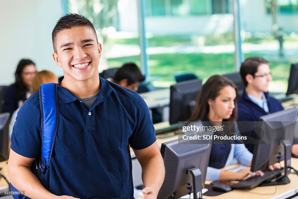 Cordial acceso privado de estudiante sonriente en el moderno Laboratorio de computación