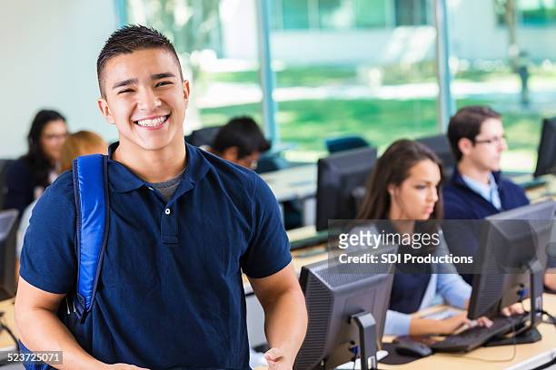 friendly private high school student smiling in modern computer lab - school boy with bag stockfoto's en -beelden