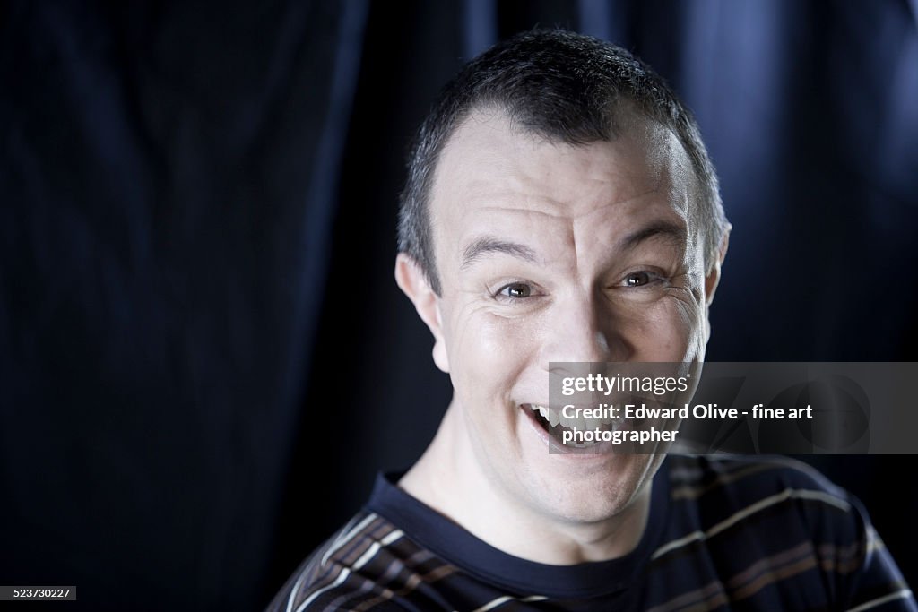 Man aged 35-45 laughing loudly, studio shot