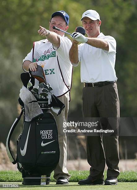 Robert Coles of England discusses strategy with his caddy "Edinburgh Jimmy" Rae on the fourth hole during the second round of the Qatar Masters at...