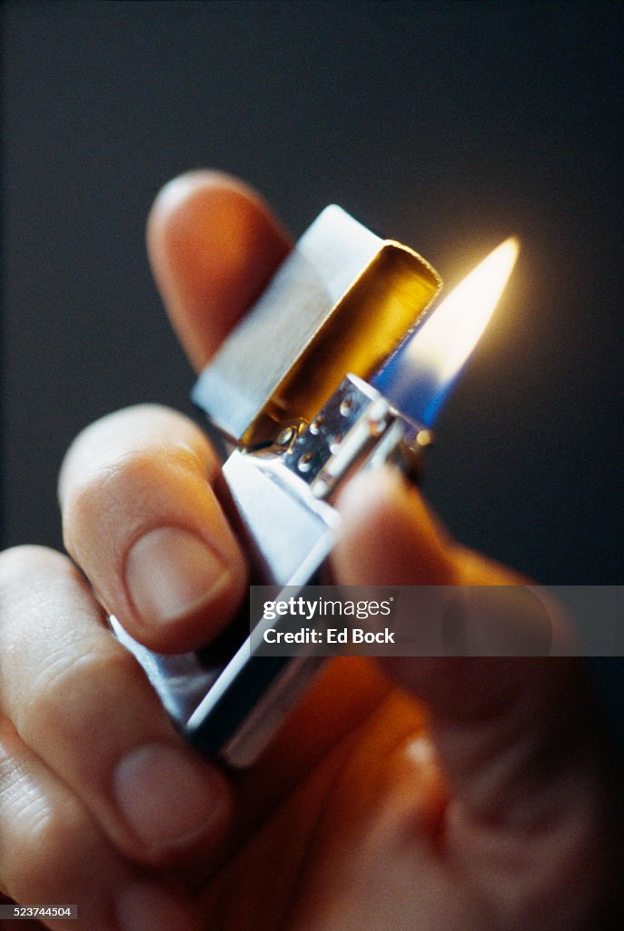Burning Cigarette Lighter in Hand