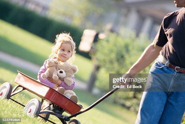 little girl riding in toy wagon - トイワゴン ストックフォトと画像