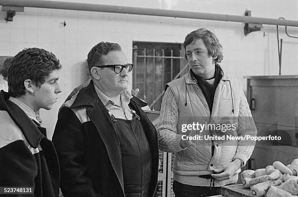 English actor Ronnie Barker pictured in character as Norman Fletcher with director Dick Clement on the set of the feature film version of the...