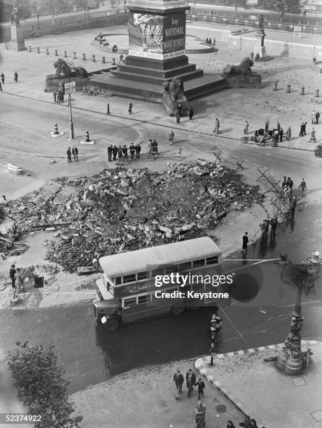 Bus makes its way past a bomb site in Trafalgar Square, London, circa 1940.
