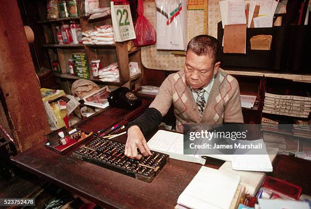 merchant balancing his ledger with an abacus - accounting abacus stock pictures, royalty-free photos & images