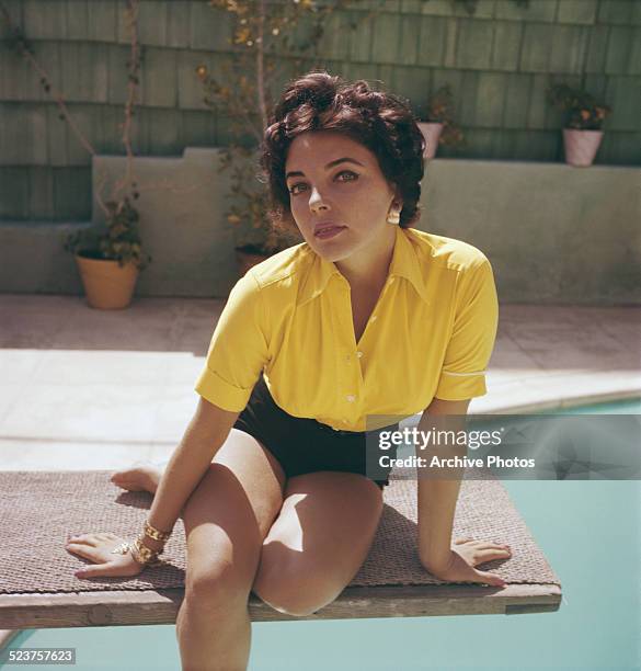 English actress Joan Collins wearing a yellow blouse and shorts, circa 1960.