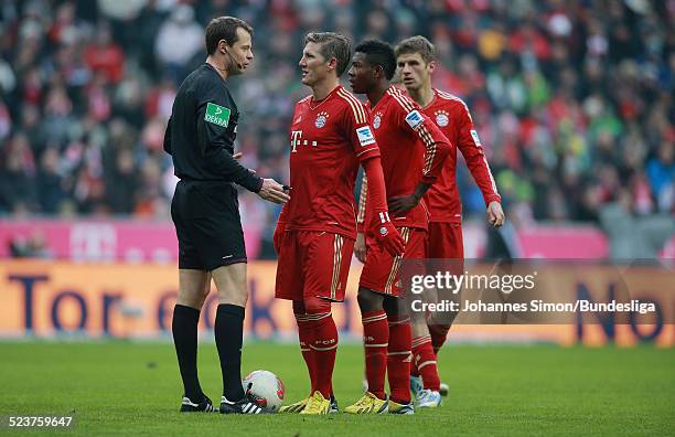 Schiedsrichter Markus Schmidt diskutiert mit den Bayern-Spielern Bastian Schweinsteiger, David Alaba und Thomas Mueller beim Bundesligaspiel FC...