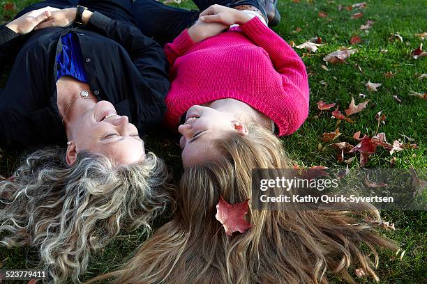 14 year old teen laughing with her mother on grass - 15 year old blonde girl fotografías e imágenes de stock
